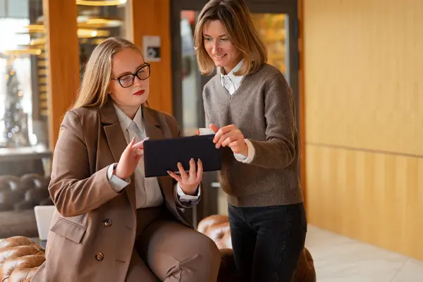 dos mujeres trabajando en un hotel con software de Aslam para temas de recepcion